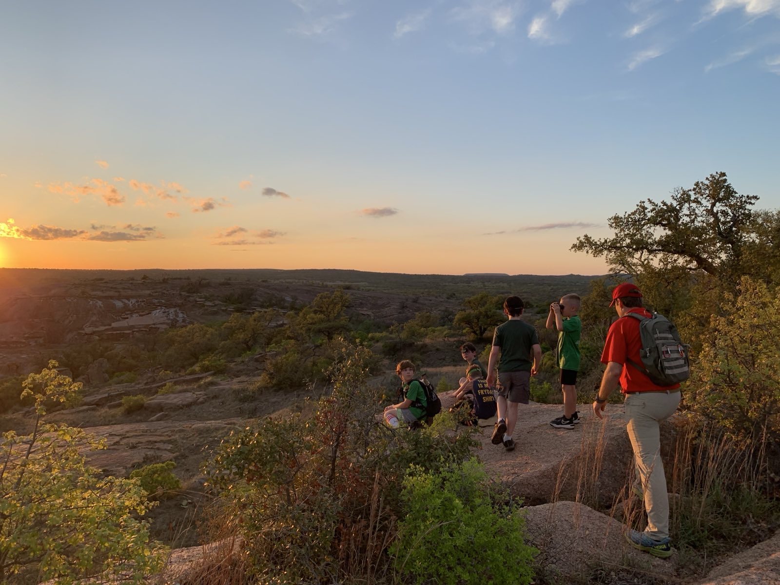 Trailmen hiking a granite overlook at sunset